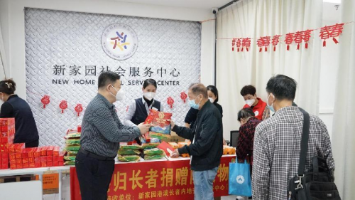 图为捐助单位与新家园志愿者共同为高龄长者赠送物资